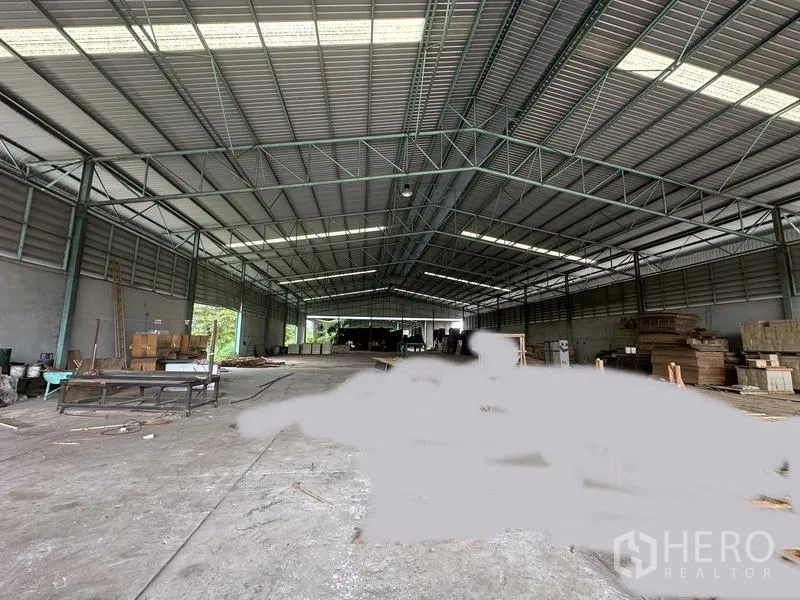 工厂 出售在Bang Bua Thong, Nonthaburi - 工厂内部空间开阔，高净空钢桁架与混凝土地面。
