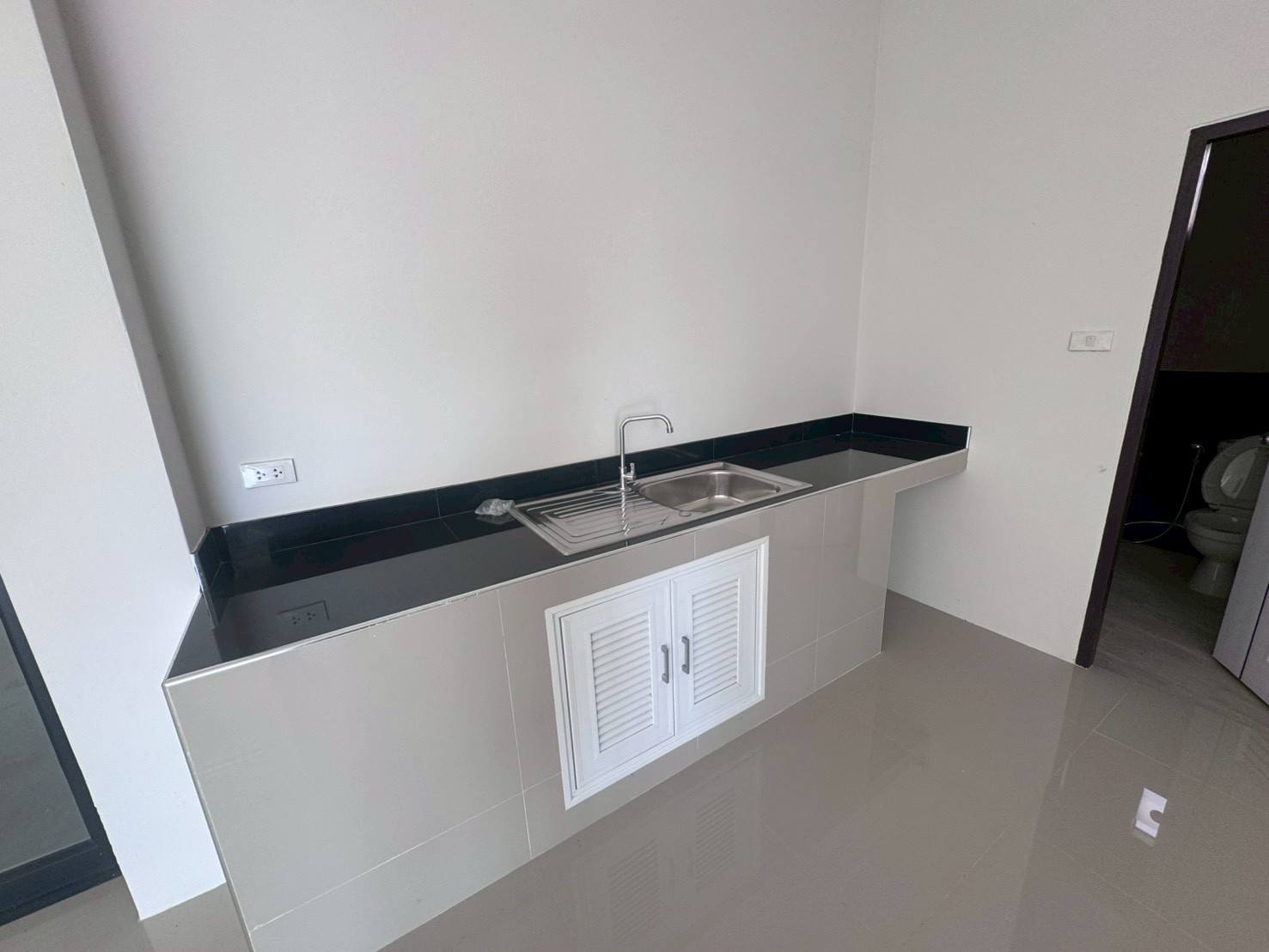 工厂 出售在Mueang Samut Sakhon, Samut Sakhon - 内置茶水间，黑色台面与不锈钢水槽，墙面铺砖。