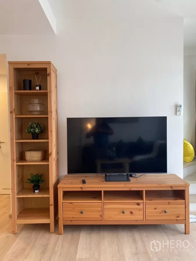 联排别墅 出租在Prawet, Bangkok - 客厅电视墙，木质电视柜与书架。