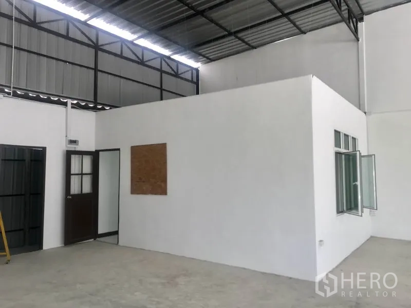 Warehouse for rent in Lam Luk Ka, Pathum Thani - Internal office unit with door and window inside the warehouse.