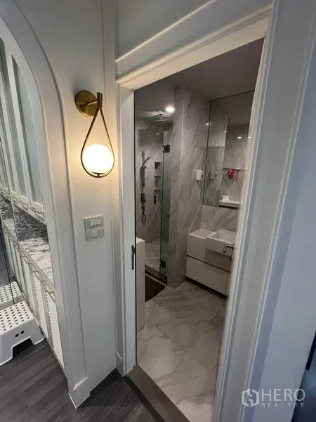 公寓 出售在Ratchathewi, Bangkok - 浴室入口设壁灯、台盆柜与玻璃淋浴间，风格现代。