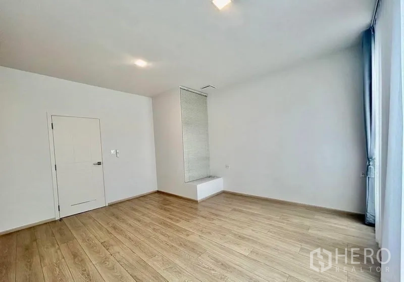 Townhouse for rent in Bang Phli, Samut Prakan - Large bedroom with wood floors, recessed lighting and side window.