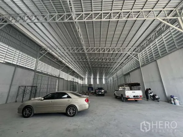 货栈 出租在Prawet, Bangkok - 宽阔仓库地面，钢桁架屋顶，车辆停放，装卸空间充足。