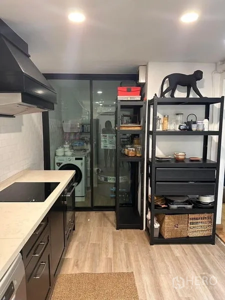 ทาวน์เฮาส์ ขายในWang Thonglang, Bangkok - ครัวสมัยใหม่ตู้สีดำ ชั้นวางเปิด และประตูกระจกสู่พื้นที่ซักล้าง