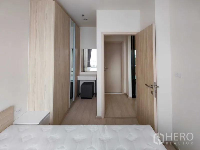 Condominium for rent - Second bedroom looking to hallway with built-in closets and vanity stool.