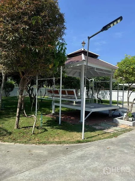 Detached House for rent in Samut Prakan - Landscaped garden featuring an open-air gazebo, lawn, and mature trees.