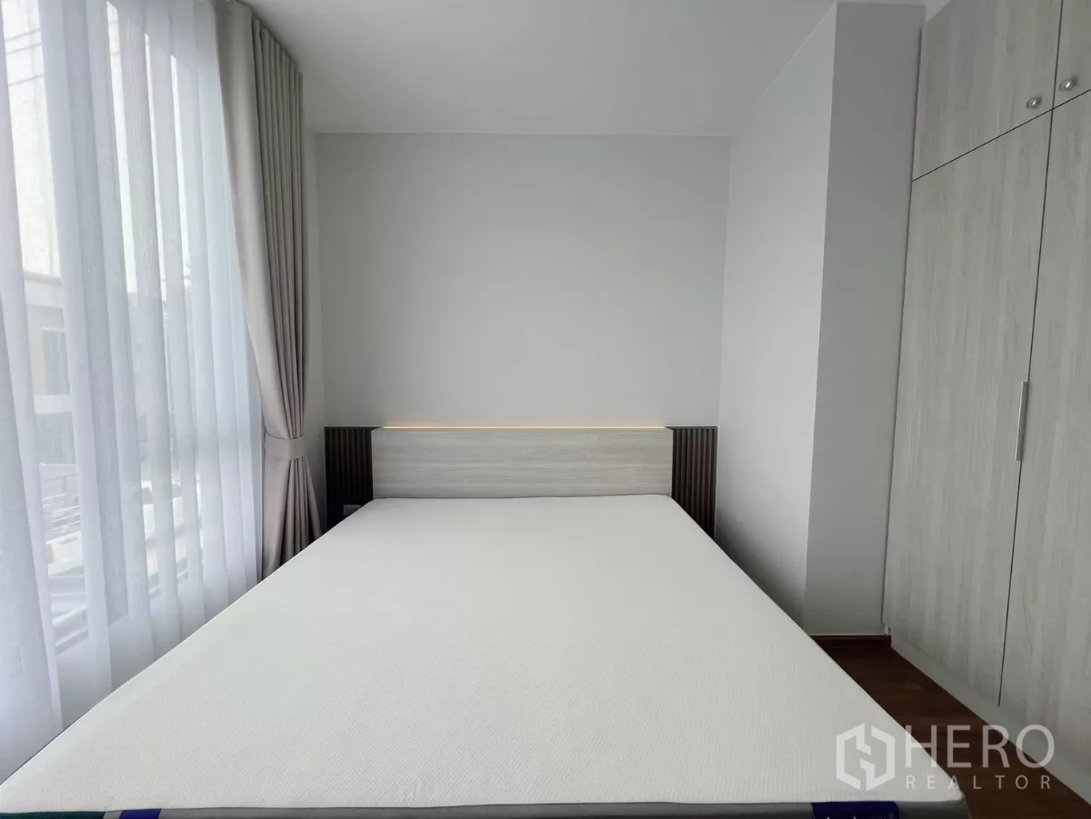 ทาวน์เฮาส์ ให้เช่าในBang Phli, Samut Prakan - ห้องนอนพร้อมเตียงติดหน้าต่างและตู้เสื้อผ้า