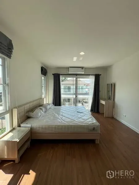 บ้าน ให้เช่าในBang Kapi, Bangkok - ห้องนอนใหญ่สว่าง มีประตูกระจกออกระเบียงและเตียงคิง