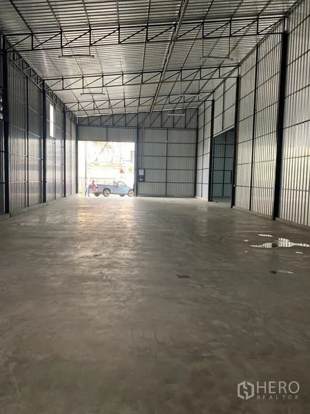 货栈 出租在Khan Na Yao, Bangkok - 开阔仓库空间朝向入口，卡车可进出，金属包板墙面。