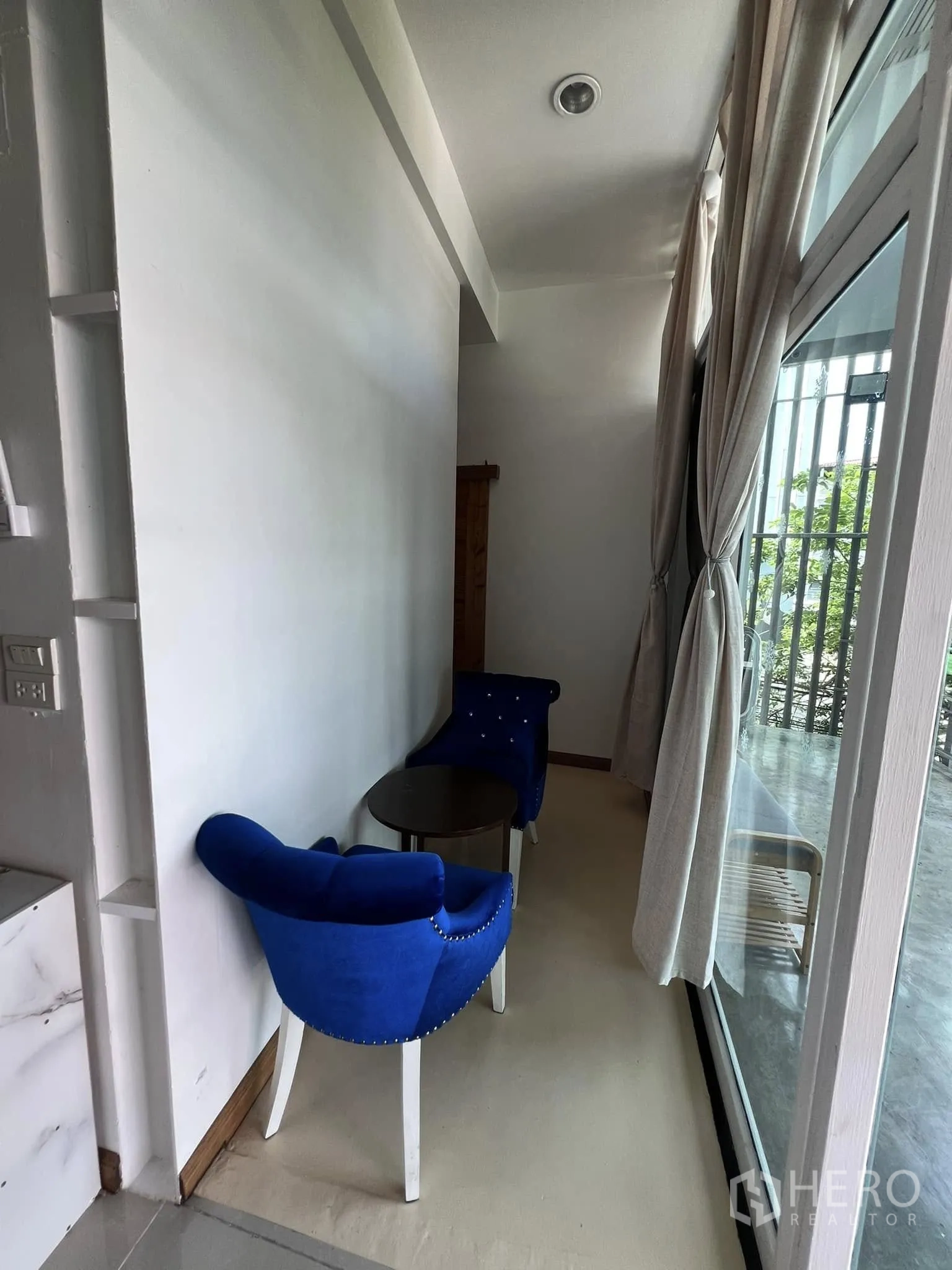 Retail Space for rent in Lat Phrao, Bangkok - Small seating nook with two blue chairs and a side table by a window.
