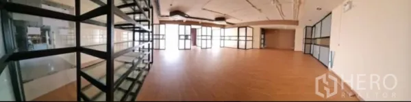 零售空间 出租在Chatuchak, Bangkok - 宽敞店铺空间，木纹地面，层架与落地窗。