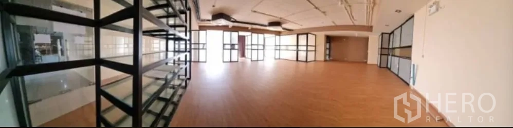 零售空间 出租在Chatuchak, Bangkok - 宽敞店铺空间，木纹地面，层架与落地窗。