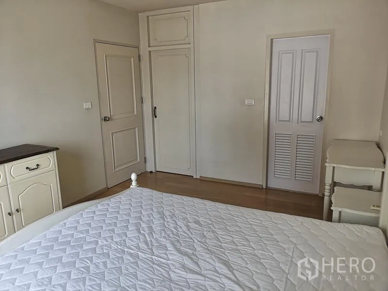 Condominium for rent or sale in Phaya Thai, Bangkok - Bedroom corner showing doors to closet and bathroom with storage cabinets.