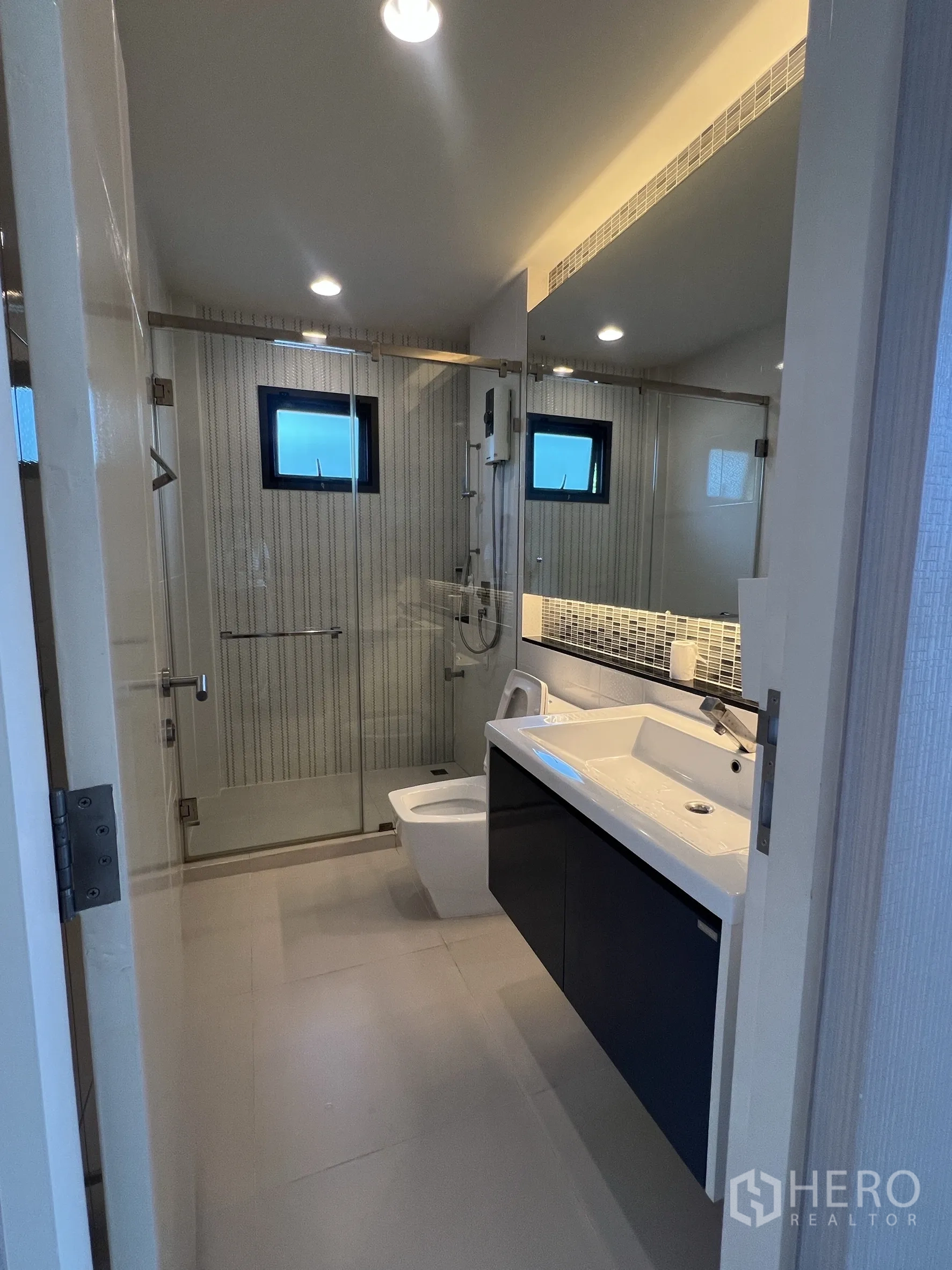 独立式住宅 出租在Bang Kapi, Bangkok - 现代浴室，玻璃淋浴间、悬挂洗手台与坐便。