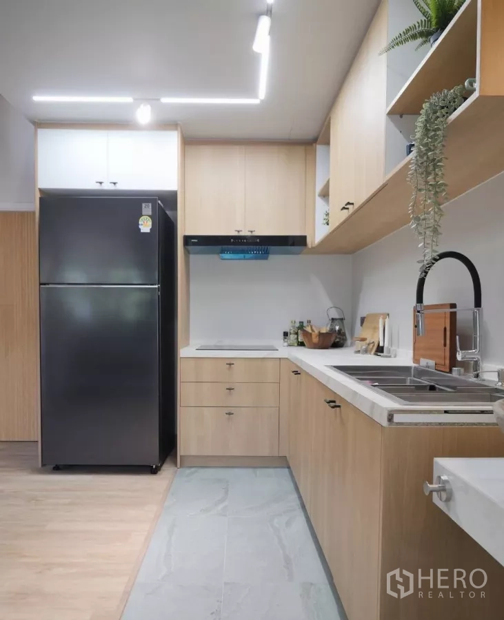 ทาวน์เฮาส์ ให้เช่าในWatthana, Bangkok - ครัวรูปตัวแอล ตู้ไม้โทนอ่อน ตู้เย็นสีดำ และไฟส่องสว่าง