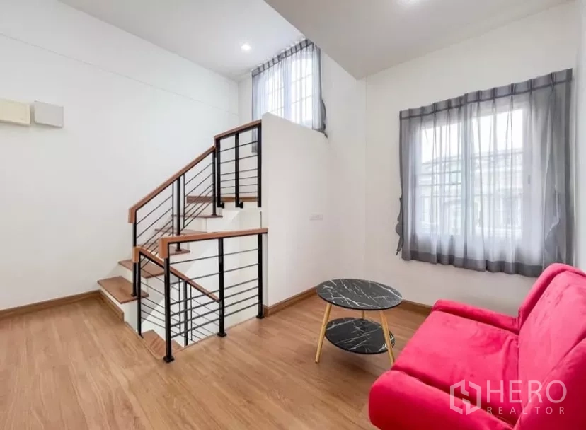 独立式住宅 出租在Chom Thong, Bangkok - 二层楼梯厅，木地板、现代楼梯与红色沙发。