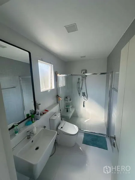 独立式住宅 出租在Prawet, Bangkok - 现代卫生间，玻璃淋浴间、采光窗与白色洁具。