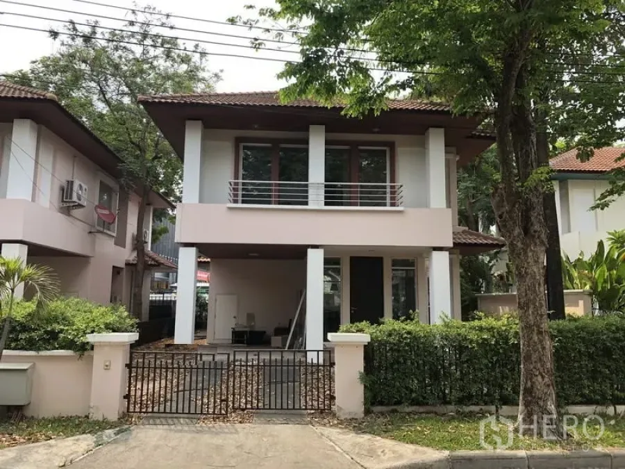 บ้าน ขายในWang Thonglang, Bangkok - บ้านเดี่ยวสองชั้นพร้อมระเบียง โรงจอดรถในรั้ว และต้นไม้ใหญ่ด้านหน้าโครงการ.