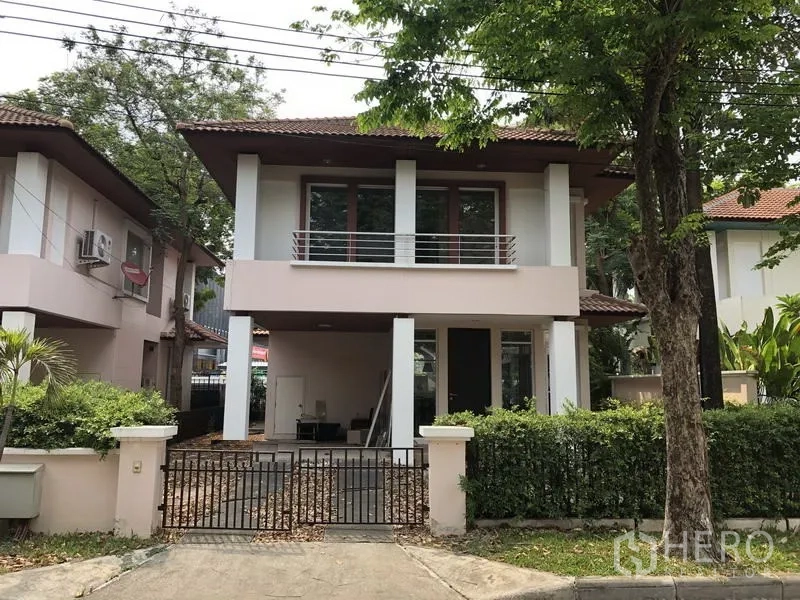 บ้าน ขายในWang Thonglang, Bangkok - บ้านเดี่ยวสองชั้นพร้อมระเบียง โรงจอดรถในรั้ว และต้นไม้ใหญ่ด้านหน้าโครงการ.