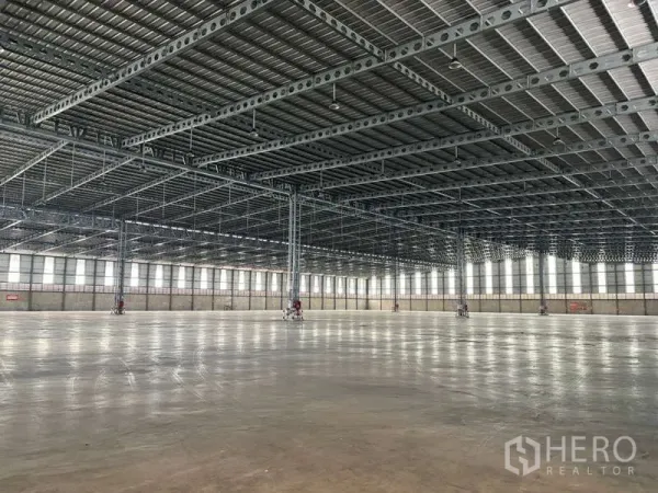Warehouse for rent in Bang Phli, Samut Prakan - Industrial space with heavy-duty steel structure, glossy concrete slab, and continuous window panels.