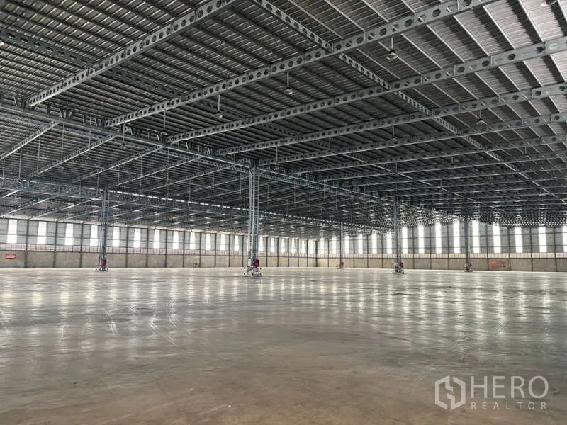 Warehouse for rent in Bang Phli, Samut Prakan - Industrial space with heavy-duty steel structure, glossy concrete slab, and continuous window panels.