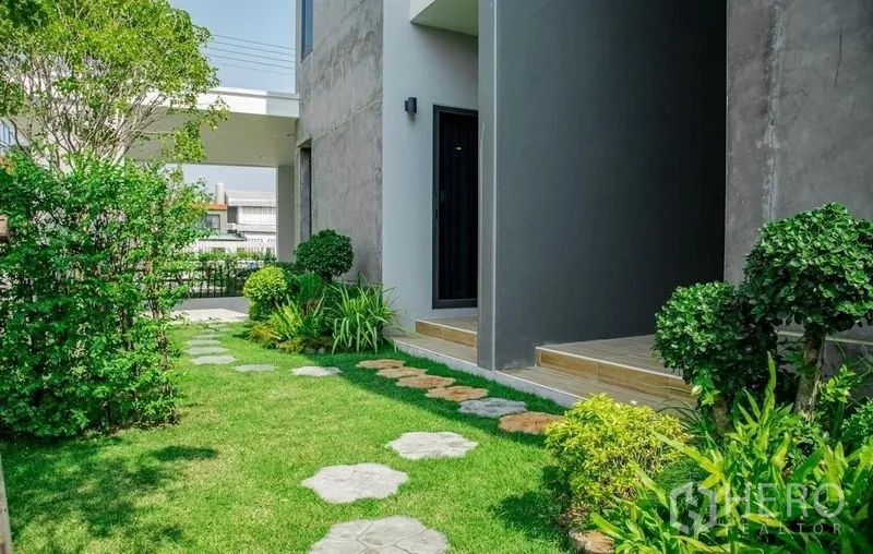 บ้าน ขายในLam Luk Ka, Pathum Thani - สวนข้างบ้าน พร้อมทางเดินแผ่นหินและไม้พุ่ม