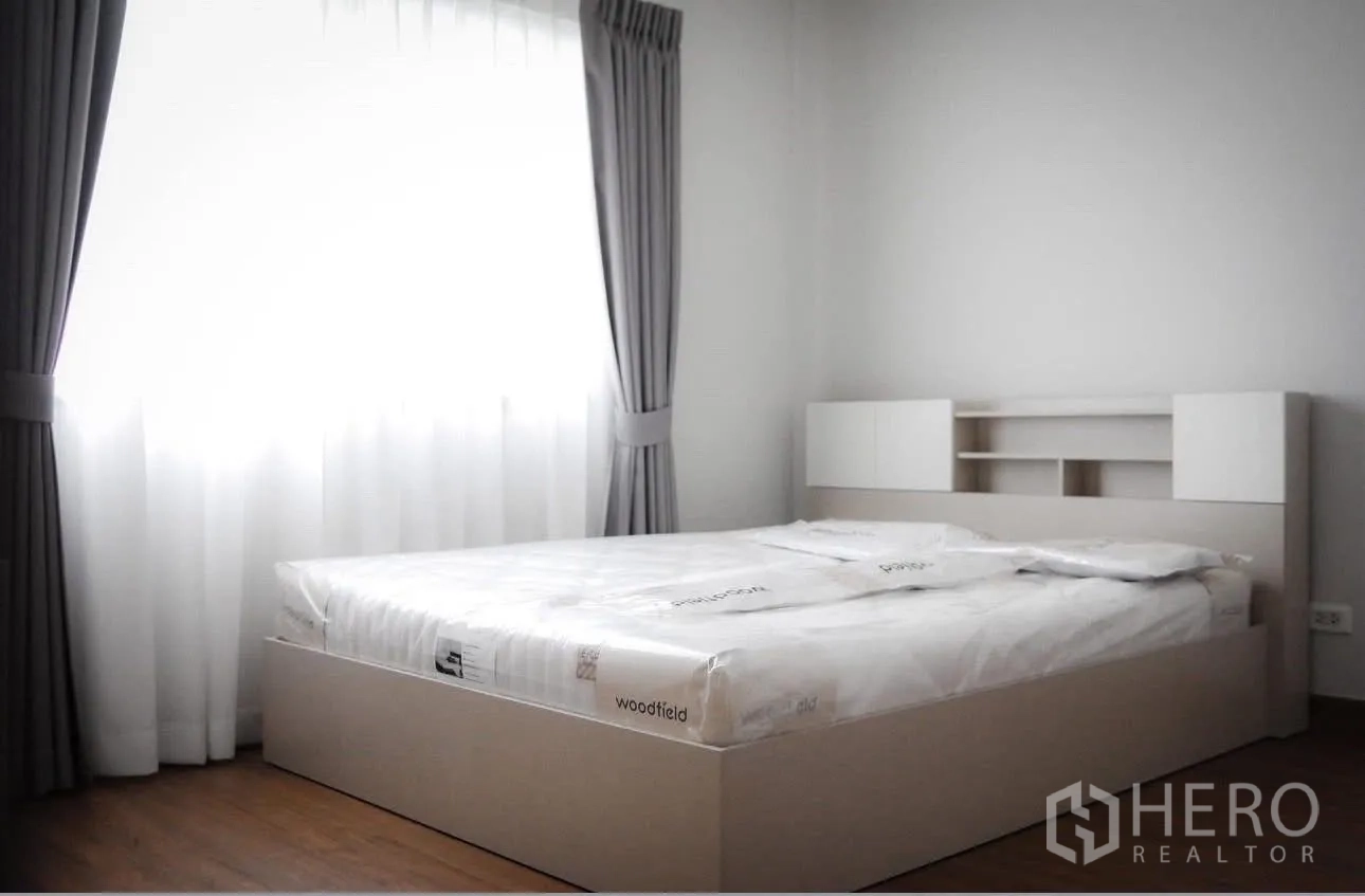 Detached House for rent in Bang Phli, Samut Prakan - Bright bedroom with double bed, grey curtains, and wood flooring.