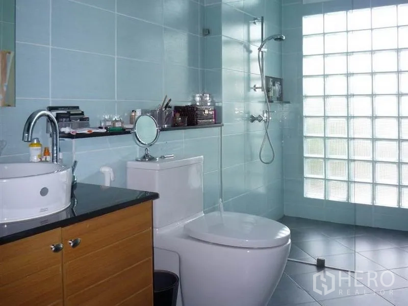 บ้าน ให้เช่าในKhan Na Yao, Bangkok - ห้องน้ำโทนฟ้า มีฝักบัวผนังกระจกบล็อก โถสุขภัณฑ์ และเคาน์เตอร์อ่างล้างหน้า