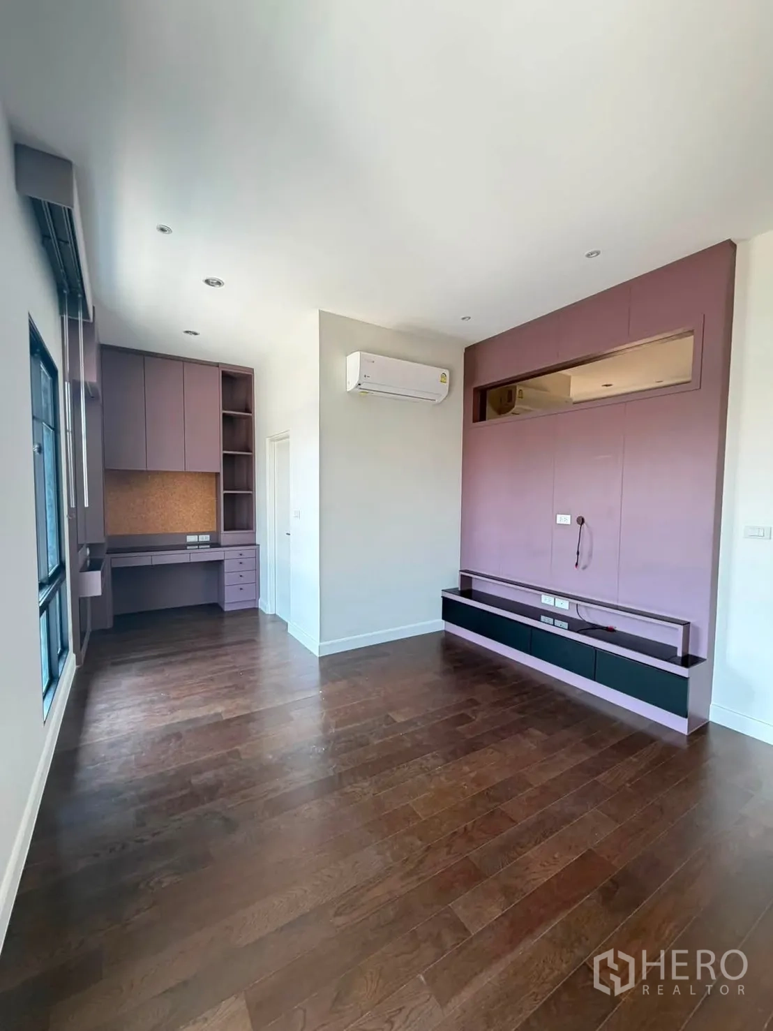 Detached House for rent or sale in Prawet, Bangkok - Bedroom with study desk, pink built-ins, and wood floors.