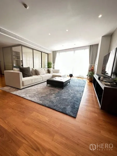 คอนโด ขายในWatthana, Bangkok - ห้องนั่งเล่นกว้าง โซฟาตัวแอล ตู้ทีวี พรมผืนใหญ่ และประตูกระจกบานเลื่อนสว่าง