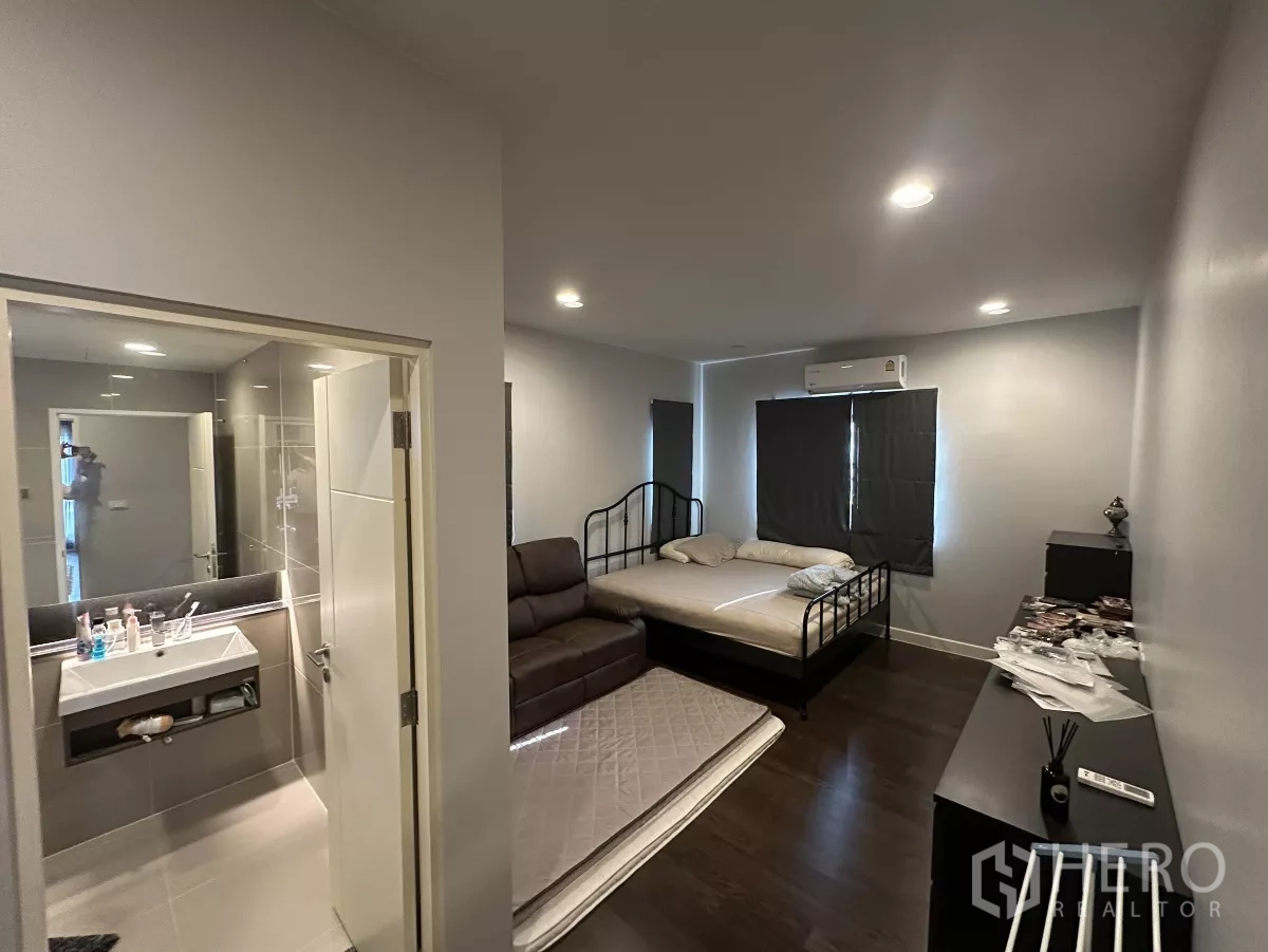 บ้าน ให้เช่าหรือขายในLam Luk Ka, Pathum Thani - ห้องนอนเชื่อมทางเข้าห้องน้ำในตัว มีเตียง โซฟา เครื่องปรับอากาศ และม่านทึบ