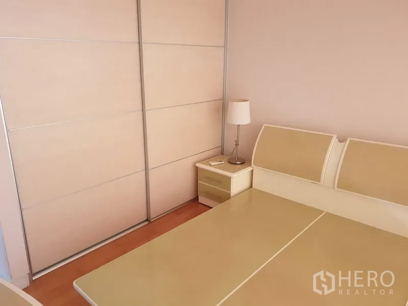 คอนโด ให้เช่าในWatthana, Bangkok - ห้องนอนรองมีฐานเตียงคู่ โต๊ะข้างเตียงพร้อมโคมไฟ และตู้เสื้อผ้าบานเลื่อนขนาดใหญ่