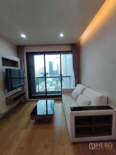 公寓 出租在Bang Rak, Bangkok - 明亮客厅，沙发、壁挂电视与阳台城市景观