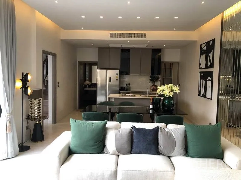 独立式住宅 出售在Bang Kapi, Bangkok - 现代客厅对望带中岛的厨房，筒灯与不锈钢冰箱。
