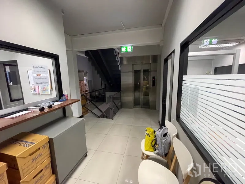 Office Space for rent in Khlong Toei, Bangkok - Lift lobby with elevator, waiting chairs and frosted glass partition.