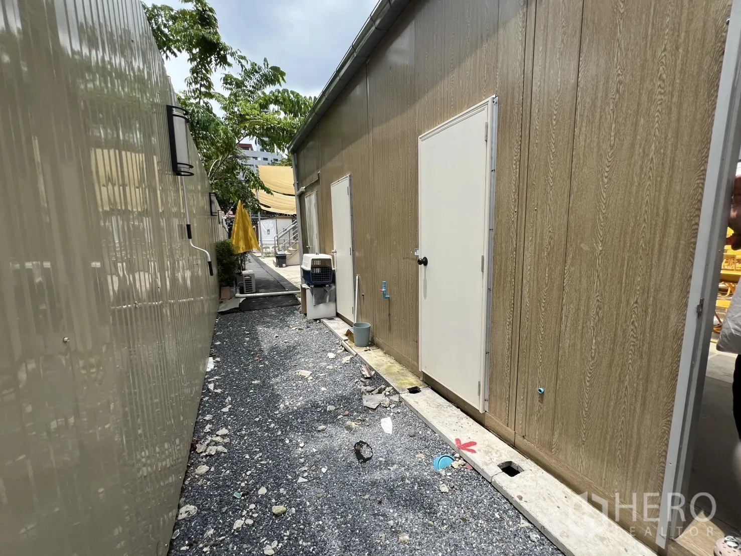 พื้นที่ขายปลีก ให้เช่าในKhlong Toei, Bangkok - ทางเดินโรยหินด้านข้าง มีประตูเซอร์วิส มิเตอร์ และต้นไม้ร่มเงา เชื่อมสู่ลานกลาง