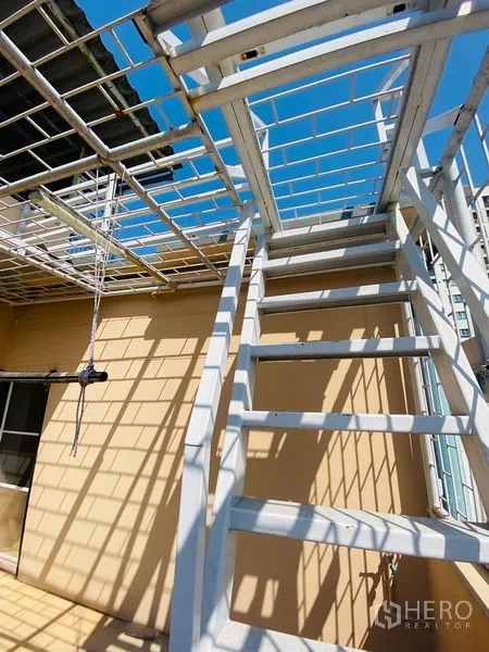 店屋 出租或出售在Suan Luang, Bangkok - 金属楼梯通往屋顶区域，蓝天下视野通透。