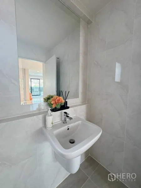 Detached House for rent or sale - Clean guest washroom with wall-mounted sink, large mirror and light gray tiles.