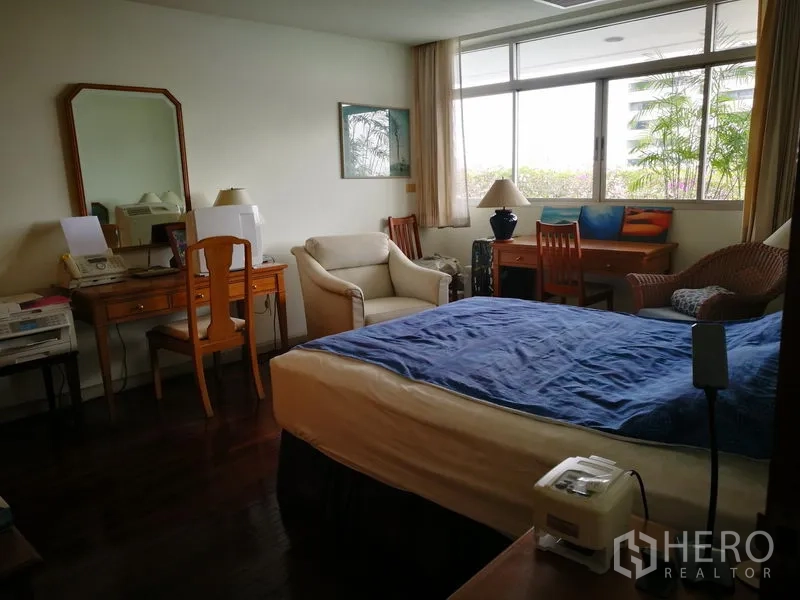 公寓 出租或出售在Watthana, Bangkok - 采光充足的卧室，配大窗、书桌和休闲座椅。