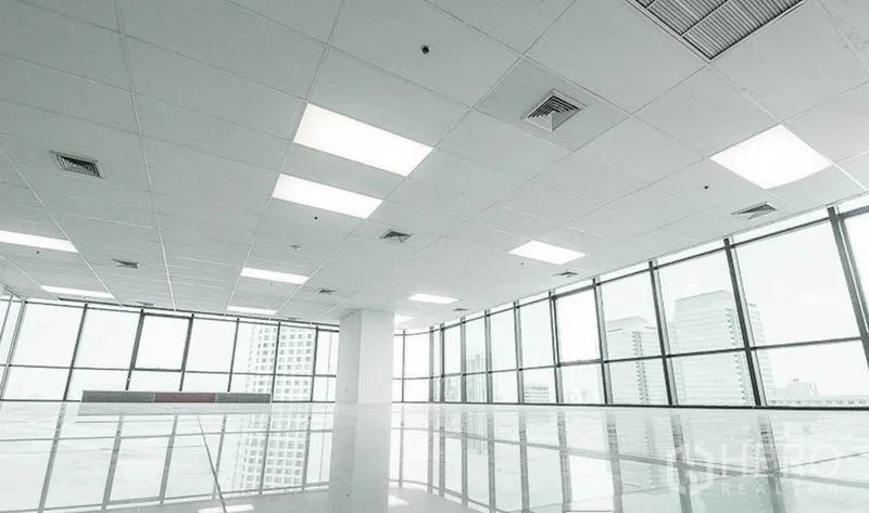 Office Space for rent in Huai Khwang, Bangkok - Close-up of floor-to-ceiling windows and grid ceiling with LED panels overlooking the skyline.