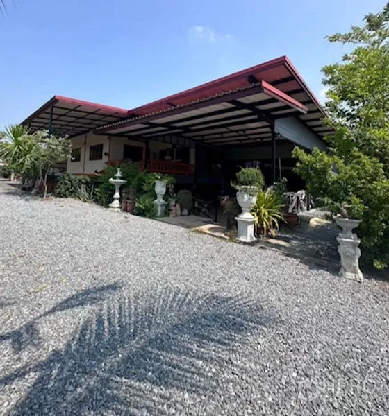 Detached House for sale in Bang Bua Thong, Nonthaburi - Exterior of single-storey house with extended metal-roof veranda and garden planters.