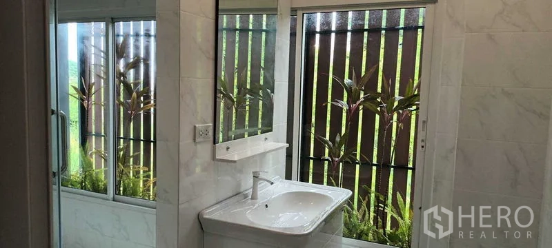 联排别墅 出租或出售在Saphan Sung, Bangkok - 现代卫浴，带洗手台、大窗户与花园景致。