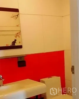 办公空间 出租在Khlong Toei, Bangkok - 盥洗区设挂镜、白色台盆与红色点缀墙砖。