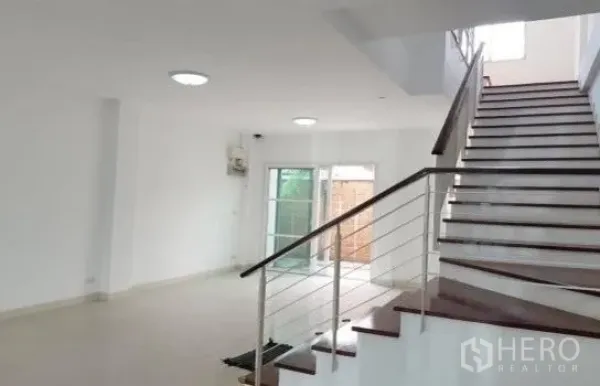 Home Office for rent in Wang Thonglang, Bangkok - Wide internal staircase with metal handrail connecting airy, light-filled floors.