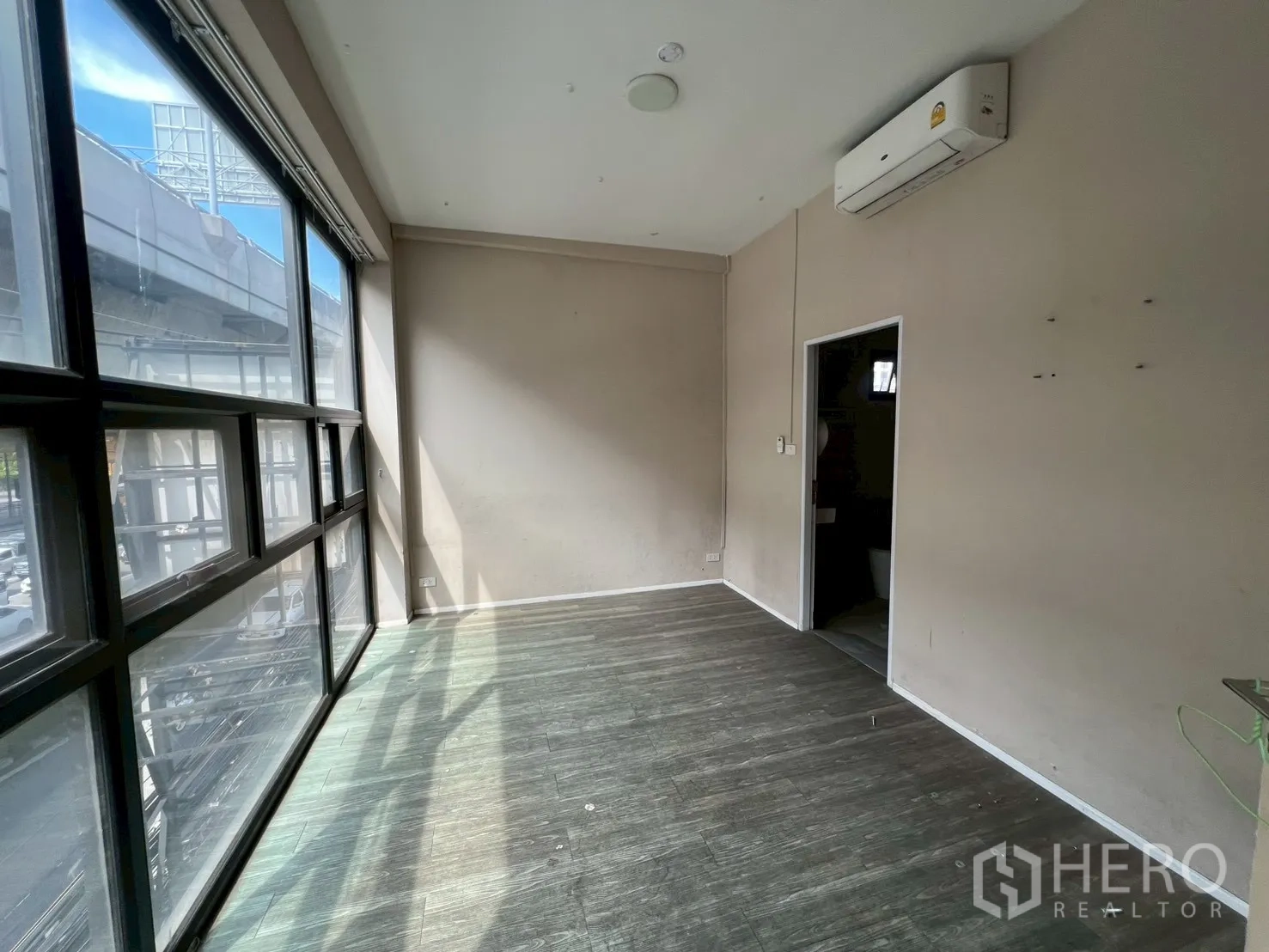 อาคารพาณิชย์ ให้เช่าในHuai Khwang, Bangkok - ห้องออฟฟิศหน้ากระจกยาว พื้นลายไม้ และแอร์แบบแยกส่วน.