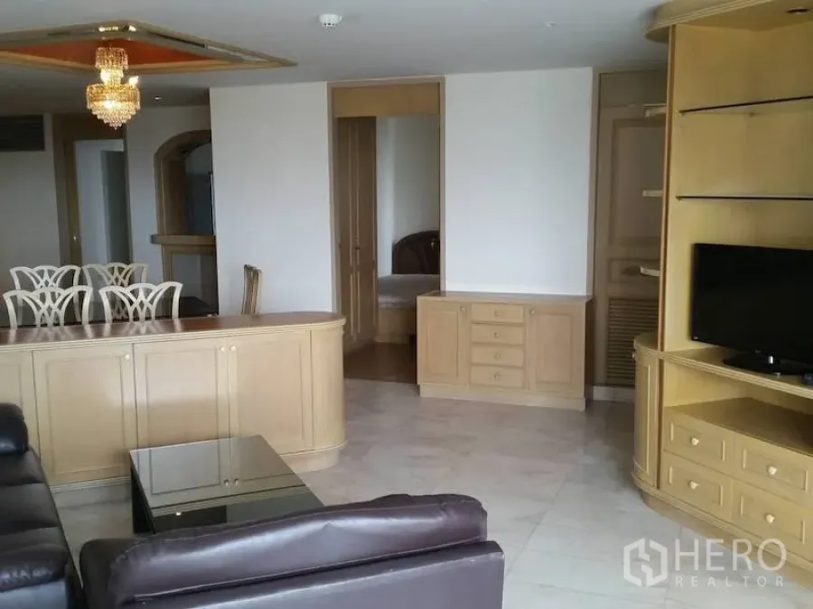 Condominium for rent in Watthana, Bangkok - Spacious living room with leather sofa, built-in TV cabinet, and chandelier in an Ekkamai condo.