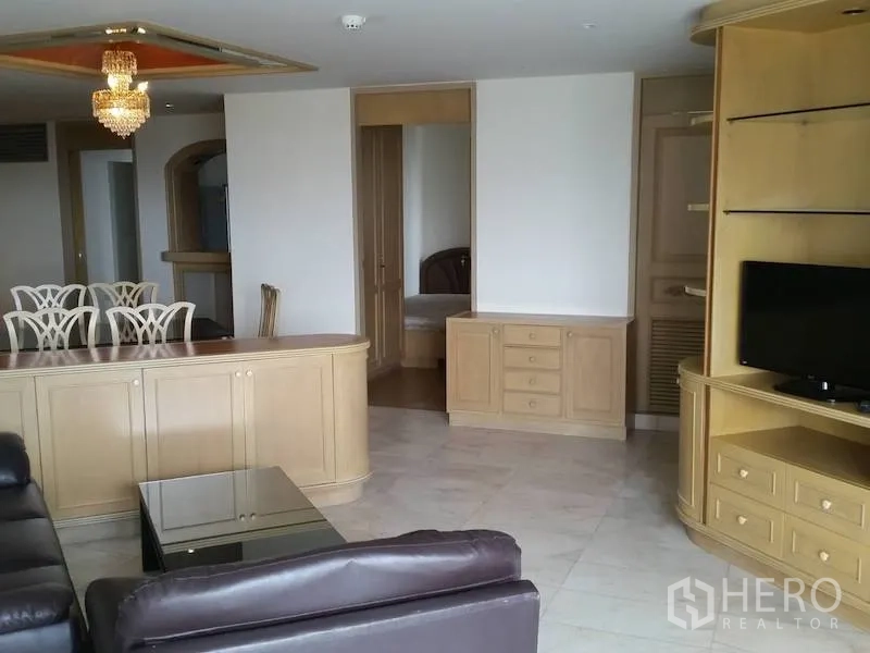 Condominium for rent in Watthana, Bangkok - Spacious living room with leather sofa, built-in TV cabinet, and chandelier in an Ekkamai condo.