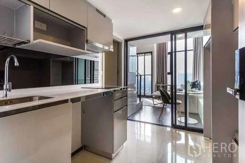 Condominium for rent or sale - Galley kitchen with stainless fixtures leading to the loft living area.
