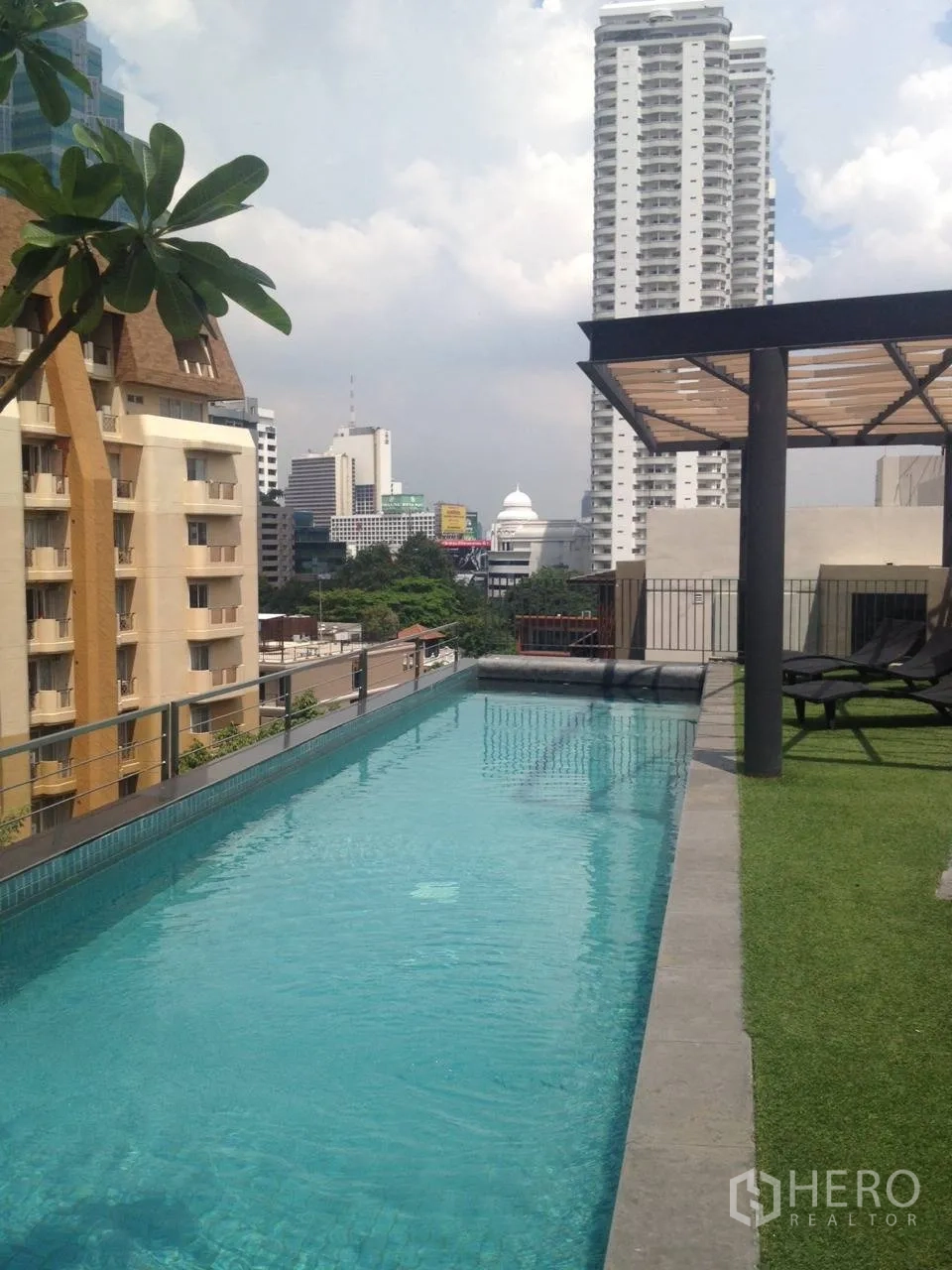 Condominium for rent in Pathum Wan, Bangkok - Rooftop lap pool with city skyline views and sun deck seating.