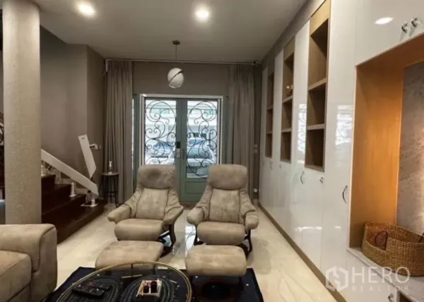 ทาวน์เฮาส์ ให้เช่าในYan Nawa, Bangkok - มุมนั่งเล่นเก้าอี้เอนกาย ตู้บิลท์อิน และประตูหน้าบ้านลายเหล็กใกล้บันได